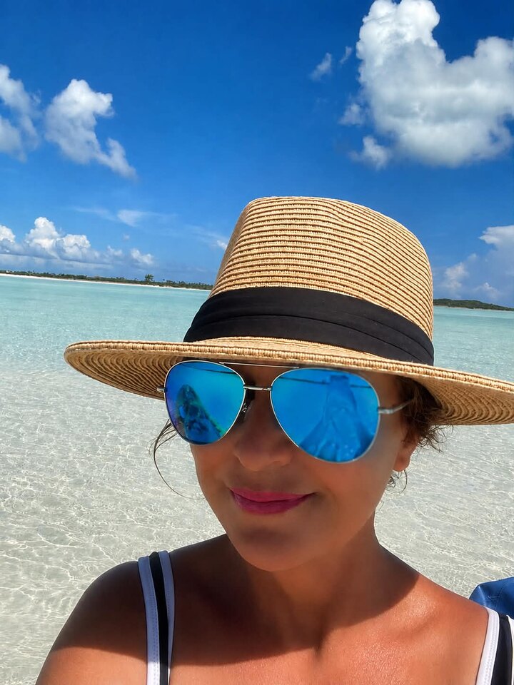 Melanie Barksdale, co-founder of Exuma Secrets, standing in the clear waters of Exuma