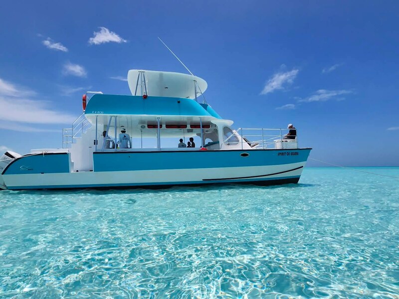 Tour boat resting in clear shallow water in the Exuma Cays