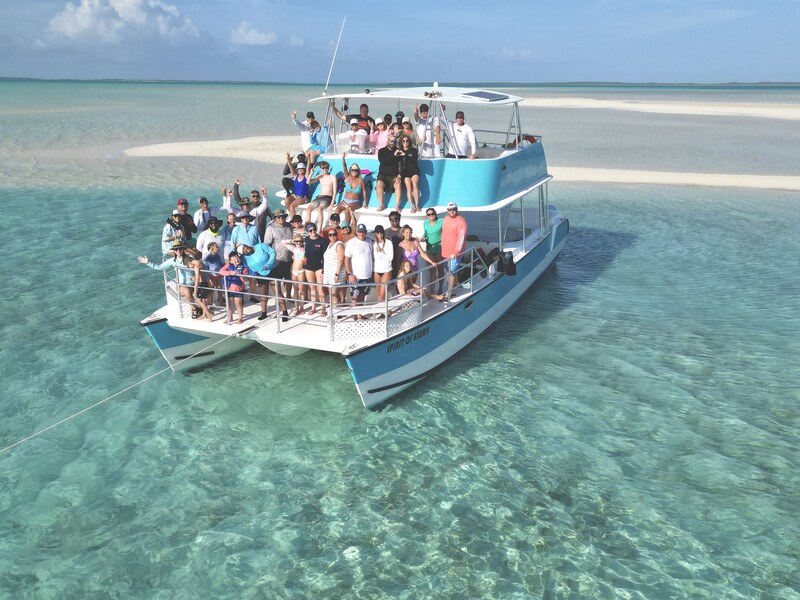 Passengers on a real boat excursion above a shallow Exuma sandbar